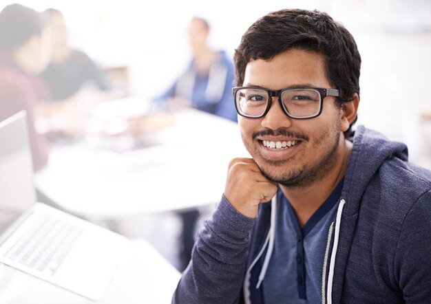 IT professional smile and portrait in office with laptop for information technology innovation web development and programming Indian person or programmer with tech for database business software