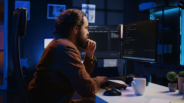 IT specialist sitting at computer desk working on desktop PC