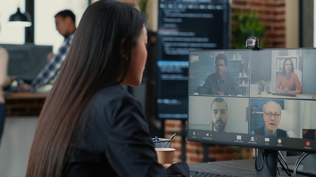 It startup employee in video call conference with client team discussing coding project deadline. Programer having online chat with clients and business owner about source code.