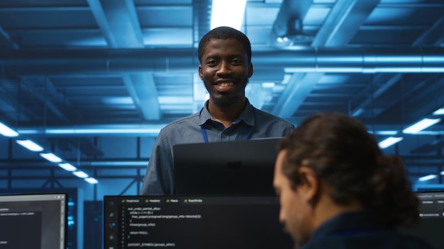 Jolly supervisor oversees technicians in data center mending supercomputers