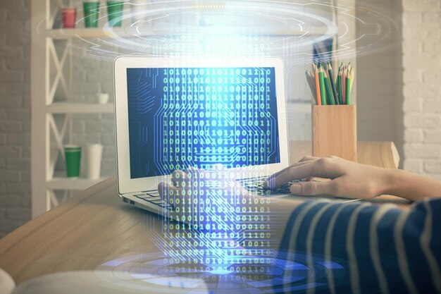 Kaksinkertainen valotus naisen käsistä työskentelemässä tietokoneella ja datateemaisen hologrammipiirroksen kanssa. Tekniikkakonsepti