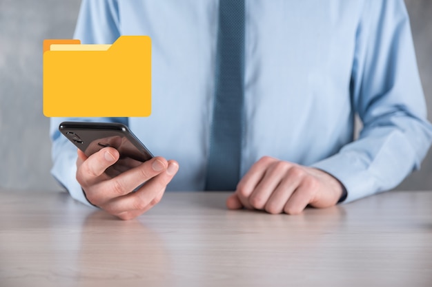 Liikemies pitää kansiokuvaketta. IT-konsultin nykyaikaisella tietokoneella määrittämä Document Management System tai DMS etsii hallintaa tietoja ja yritystiedostoja. Liiketoiminnan käsittely,