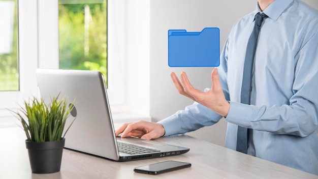 Liikemies pitää kansiokuvaketta. IT-konsultin nykyaikaisella tietokoneella määrittämä Document Management System tai DMS etsii hallintaa tietoja ja yritystiedostoja. Liiketoiminnan käsittely,