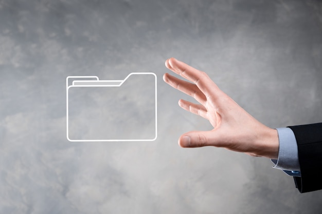 Liikemies pitää kansiokuvaketta. IT-konsultin nykyaikaisella tietokoneella määrittämä Document Management System tai DMS etsii hallintaa tietoja ja yritystiedostoja. Liiketoiminnan käsittely,