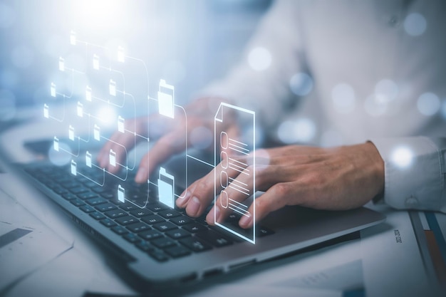 Liikemies työskentelee kannettavalla tietokoneella ja käyttää virtuaalinäyttöä. Online-dokumentaatio tietokanta IT-konsultti on asettamassa Virtual Document Management System -järjestelmää kannettavalla tietokoneella. Ohjelmisto yritystiedostojen arkistointiin