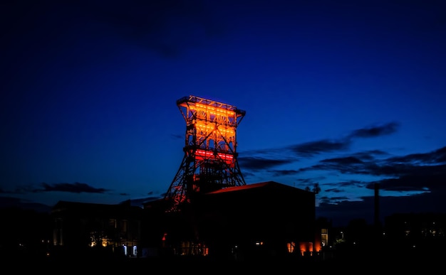 Low angle view of illuminated industrial building at night