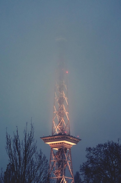 Low angle view of illuminated tower against sky at dusk