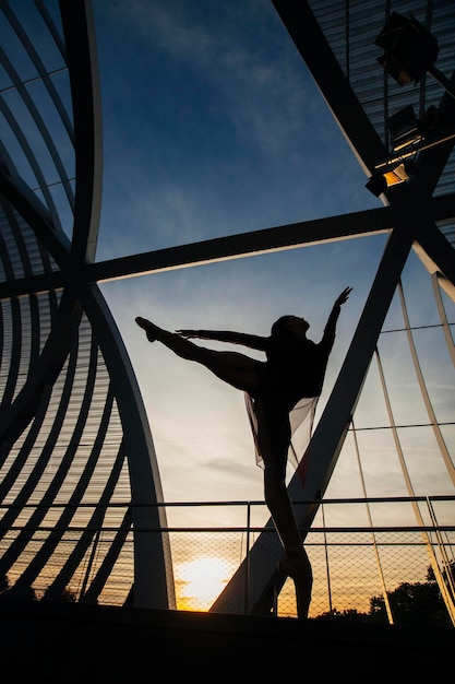 low angle view of silhouette man standing on metallic structure against sky