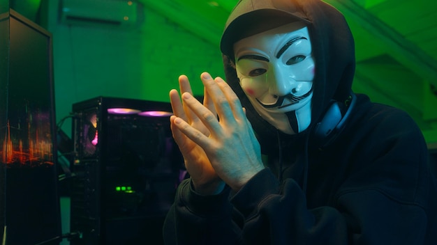 Lviv Ukraine June 03 2024 Man programmer hacker computer pc coding spy steal internet cybersecurity anonymous cyber crime attack system phishing networking monitor scammer database web fingers