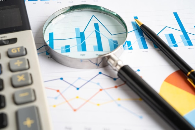 magnifying glass on graph paper financial development banking account statistics investment analytic research data economy business concept