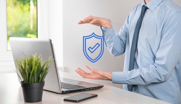 Male hand holding protect shield with a check mark icon. Protection network security