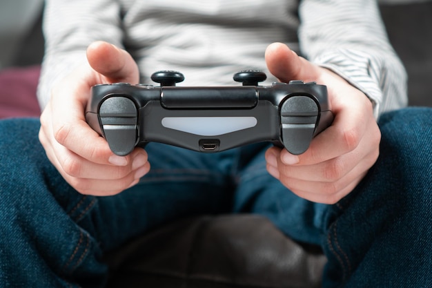 Male hands hold modified plastic joystick closeup Person play videogames Press buttons on controller by fingers