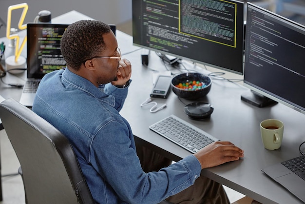 Male it engineer reviewing code searching for bugs