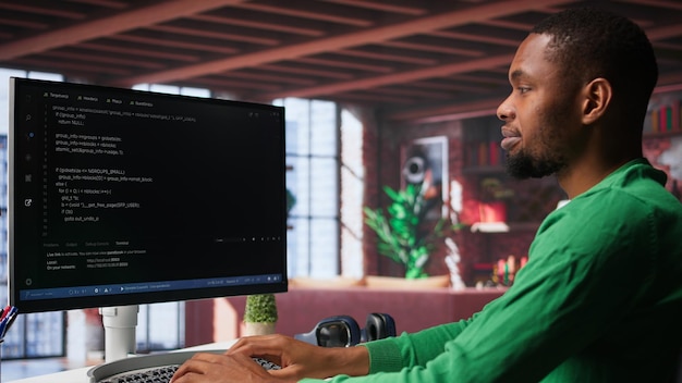 Male programmer types code on computer and running script programming language african american it