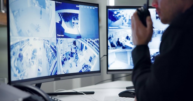 Male security guard radio and speaking by cctv monitor for protection data center or building safety Inspection control room with man and footage in video surveillance agency computer and watch