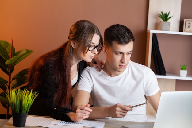 Man and woman working together on a project in the office