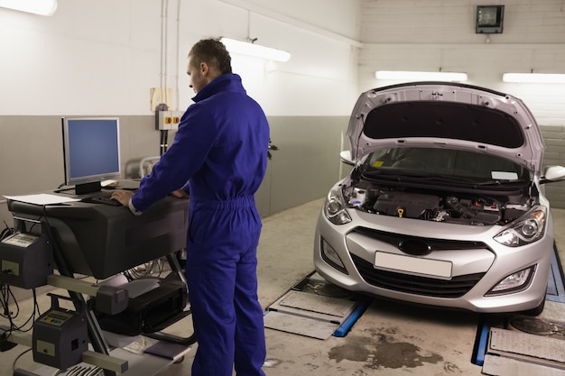Mechanic looking at a computer while standing