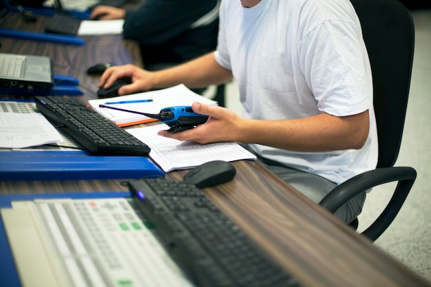 Midsection of man holding walkie-talkie while working at office desk