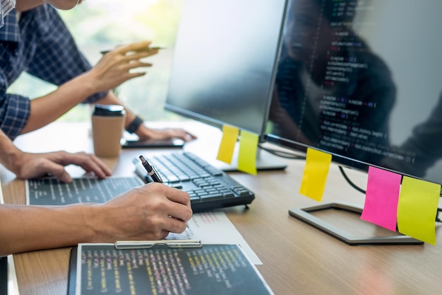 Midsection of man using computer with colleague at office