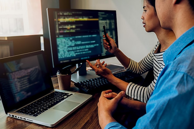 Midsection of man working with colleague on technologies in office