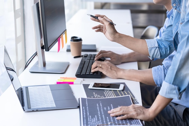 Midsection of programmers working on table