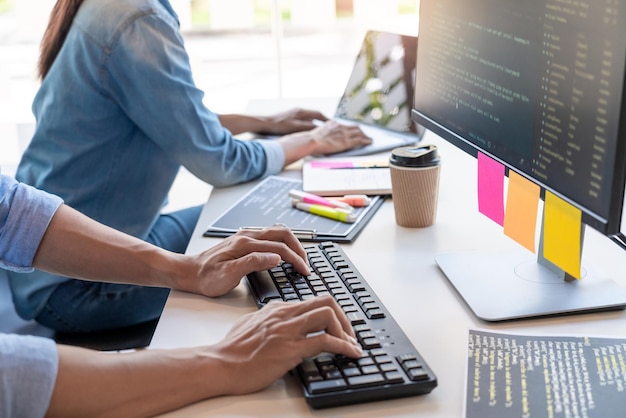 Midsection of programmers working on table