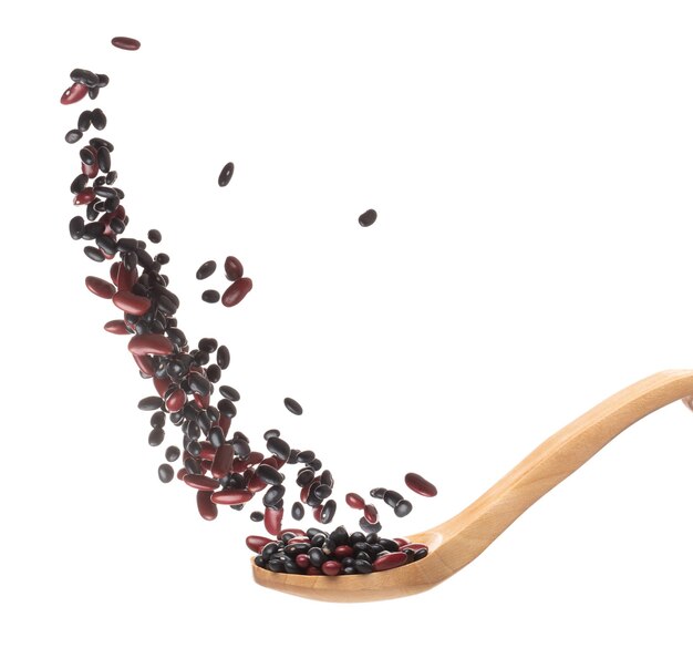Mix black red beans fall down explosion several kind bean float pouring in wooden spoon Dried red black mixed beans splash throwing in Air White background Isolated high speed shutter freeze motion
