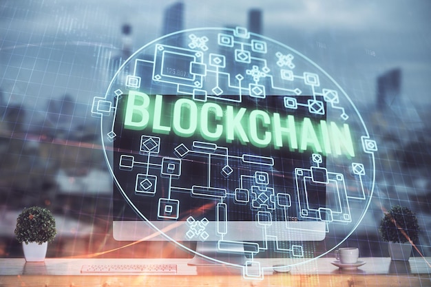 Monivalotus blockchain-teeman hologrammista ja pöydästä tietokoneen taustalla. Bitcoin-kryptovaluutan konsepti