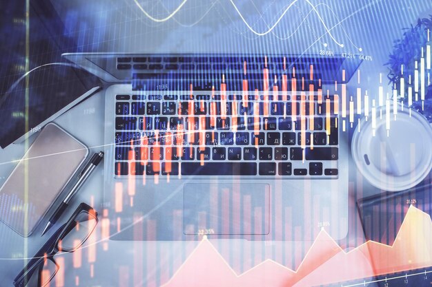multi exposure of financial chart drawing over table background with computer concept of research top view