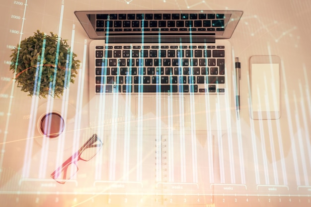 Multi exposure of forex chart drawing over table background with computer Concept of financial research and analysis Top view