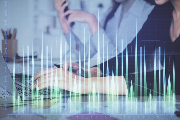 Multi exposure of woman hands typing on computer and financial graph hologram drawing Stock market analysis concept