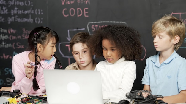 Multicultural children using laptop programing engineering code erudition