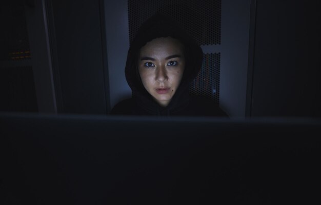 Night hacker and cyber security with woman and laptop for coding software and programming Ransomware phishing and developer with girl programmer in server for database network and digital crimes