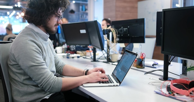 Nuori yrittäjä freelancer työskentelee kannettavalla tietokoneella coworking-tilassa
