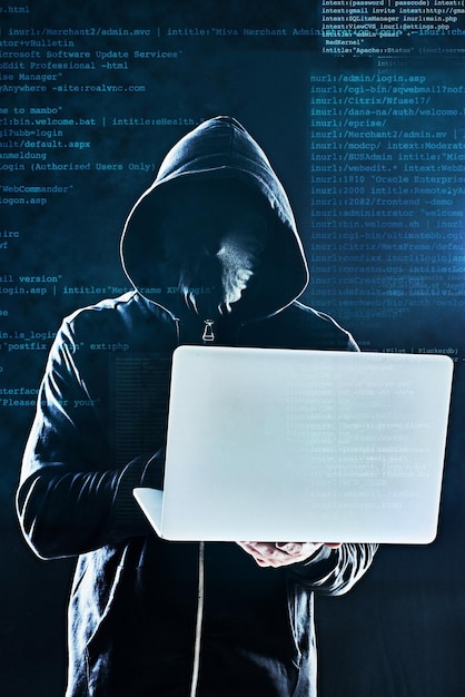 Person hoodie and laptop on black background for hacking phishing or malware distribution with virus Hacker tech and software for cyber crime coding or cryptocurrency thief with programming