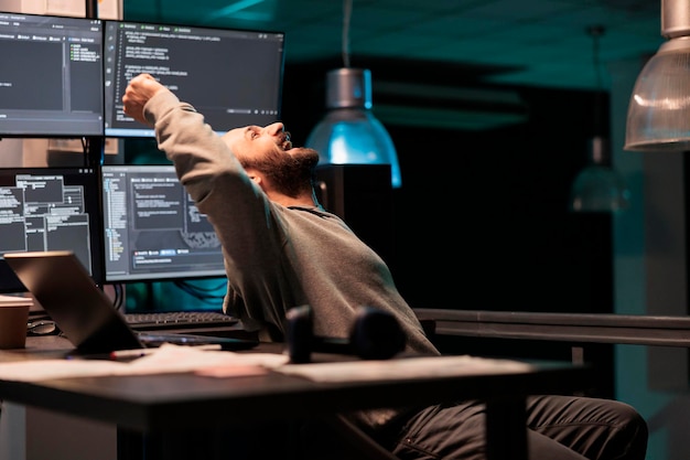 Pleased engineer celebrating ai software victory, feeling cheerful about app developing success after hours. Smiling coder programming html script or source code with system database.