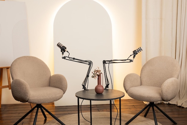 Podcast studio setup features two cozy chairs and microphones for engaging interviews