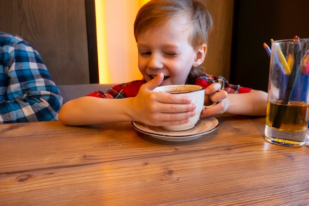 portrait of child drinking tea in cafe