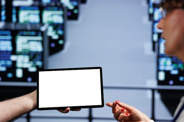 Precise coworkers using mock up tablet to check supercomputers, close up. Equipment in computer network security server room providing processing and memory resources for several workloads