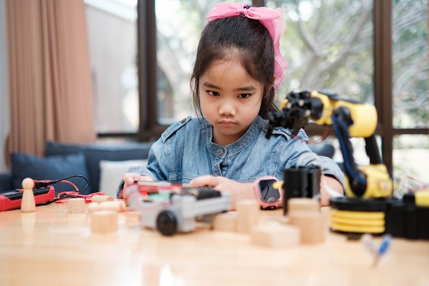 Primary School Girl Using App to Control Car in STEM Class