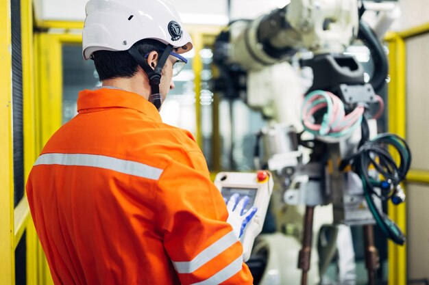 Professional engineers workers working with robotic arm system in indurtrial factory