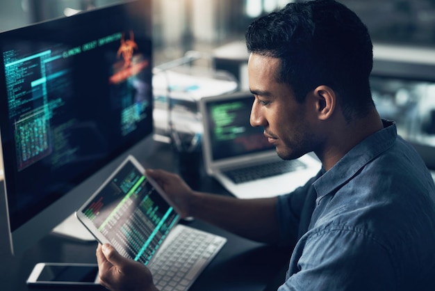 Programming employee and man with a tablet cyber security and computer in a modern office Male person programmer and coder with technology coding and digital software with internet connection