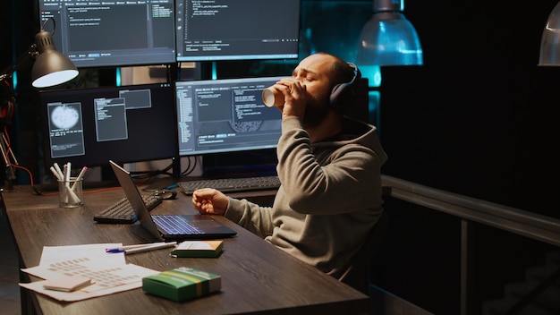 Programming engineer taking vitamins and pills in box, having package with supplements and working late at night. Young app developer using medicaments in coding agency office, html script.