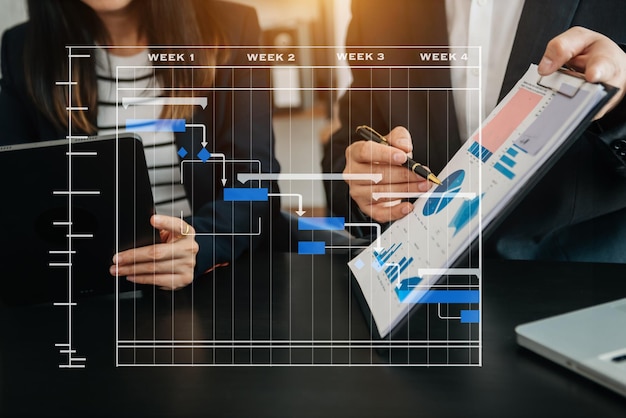 Project manager working and update tasks with milestones progress planning and Gantt chart scheduling diagram business working with smart phone tablet and laptop in officexA