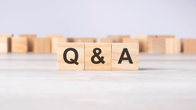 QA word concept written on wooden cubes or blocks on a light background