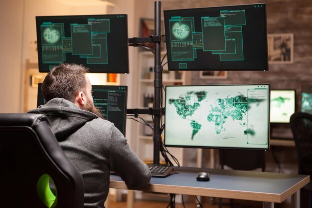 rear view of dangerous hacker typing a malware to hack government server.