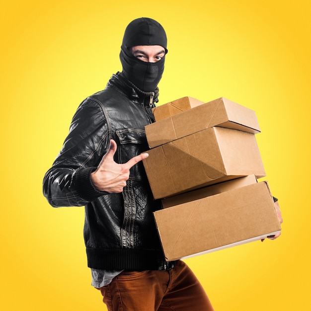 Robber holding boxes on colorful background
