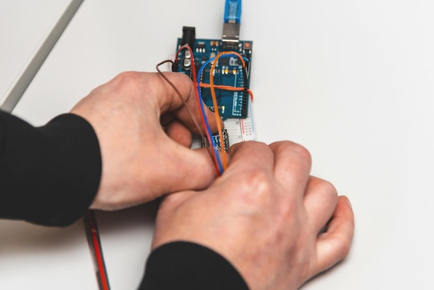 Robotics Man makes a robot Modern technologies Development of automated technical systems A mechanic is assembling a robot Closeup Stem Concept