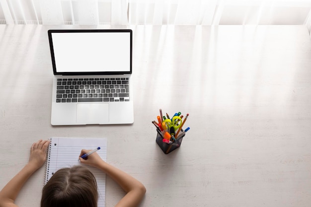 School at home through online homeschooling the child is sitting at the computer