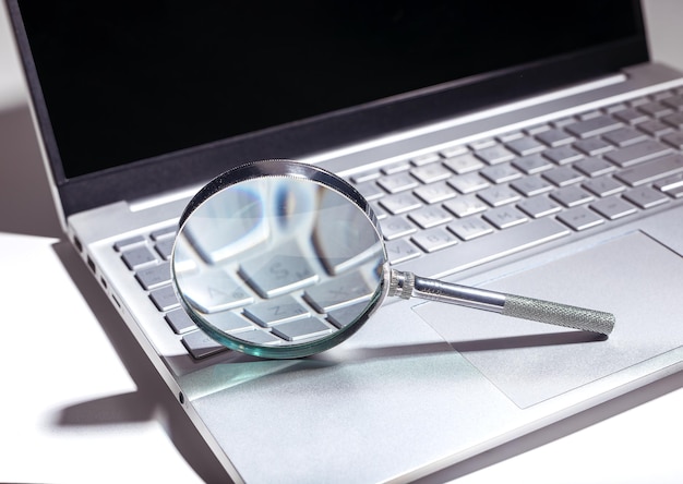 seo search concept with magnifying glass on a website web research and engine optimization in a